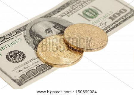 Golden bitcoin coins and one hundred dollar banknote isolated on white