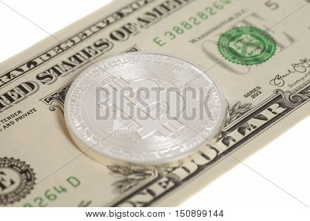 Silver bitcoin coin and one dollar banknote isolated on white