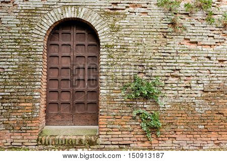 Detail of an old exterior door to the famous castle of Imola in Italy