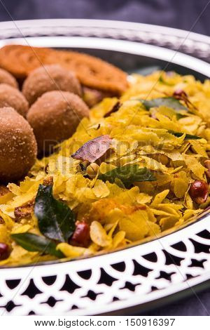 Plate full of indian festival food or diwali food or snacks like laddu, chivda, chakali or murukku, sev and shankar pale, sweet and salty snack food