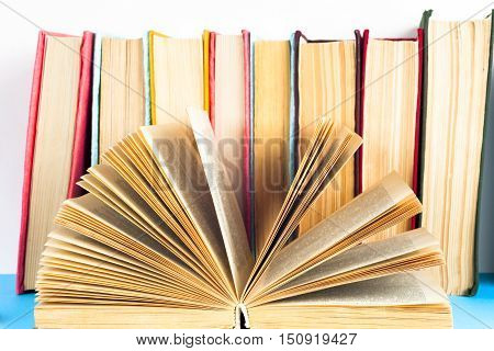 Open book stack of colorful hardback books isolated on white background. Back to school. Copy space for text. Toned image.