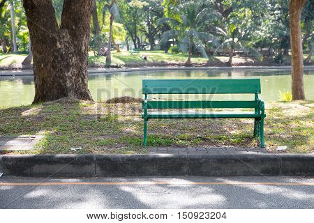 Green benches beside walkway in the park.