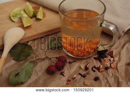 sea buckthorn tea in a transparent mug and a rose hip lime. useful warming winter drink.