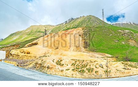 The bright orange travertine in mineral water stream channel Cross Pass Gudauri Georgia.