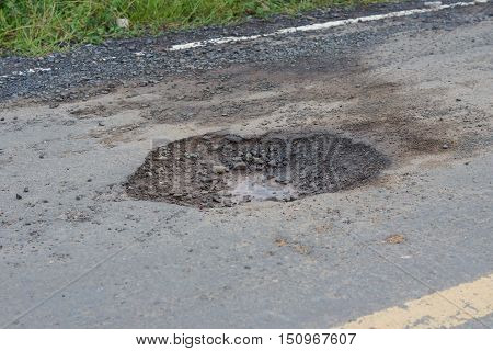 Damaged road with holes / pothole in the asphalt