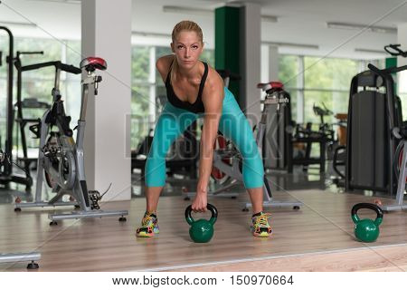 Fitness Woman Using Kettlebells Inside Gym