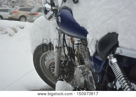 BOULDER CO USA - March 18 2016:A motorcycle parked outdoors is covered in snow following a blizzard in Colorado.