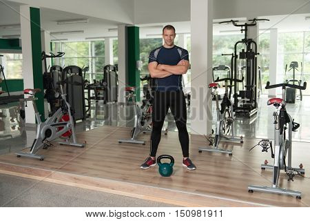Fitness Man Using Kettlebells Inside Gym