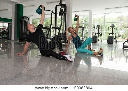Healthy Young Couple Doing Exercise With Kettle Bell