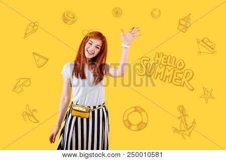 Greeting Summer. Optimistic Beautiful Young Girl Joyfully Waving Her Hand And Smiling While Greeting