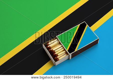Tanzania Flag  Is Shown In An Open Matchbox, Which Is Filled With Matches And Lies On A Large Flag.