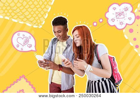 Typing Messages. Good Friends Standing Together And Holding Modern Gadgets While Sharing Messages