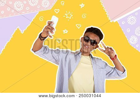 Handsome Person. Cheerful Young Person Wearing Sunglasses And Smiling While Holding A Modern Smartph