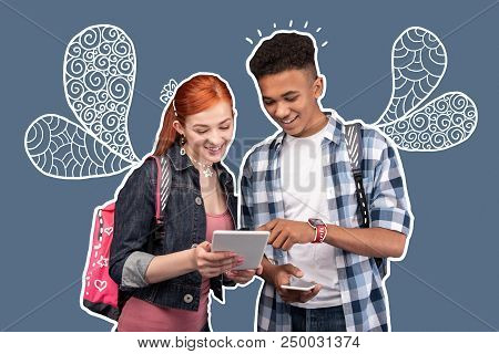 Modern Tablet. Positive Young Girl Standing With A Modern Tablet In Her Hands And Smiling While Her 