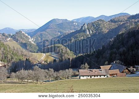 The Country Houses On The Background Of The Winter Austrian Alps Covered With Trees