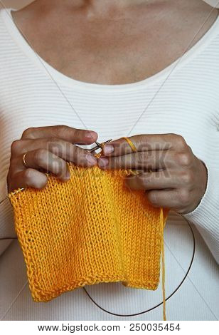 A Girl Knits Cotton Clothes.  Close-up Knitting On Knitting Needles, Needlework.