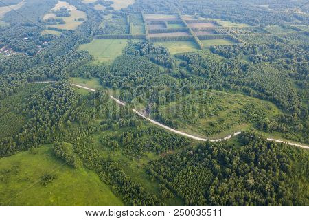 Helicopter Drone Shot. View From Above On A Small Village, Motor Road, Green Forest And A Large Fiel