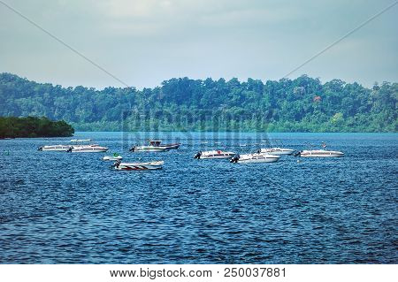 The Small Speedboat Is Mooring In The Wavy Sea Near The Shore With The Background Of The Sea Horizon