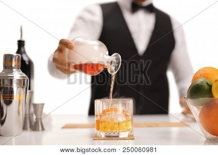 Bartender pouring whiskey in a glass isolated on white background