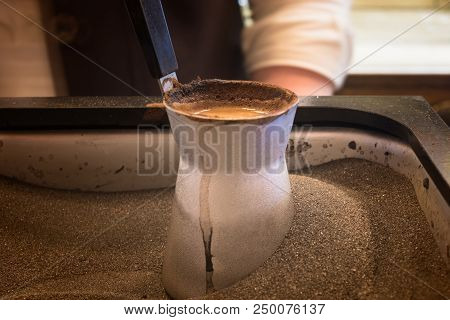 Preparing Coffee In Coffee Jezva In Sand. Turkish Method Of Preparing Coffee. Eastern Coffee.