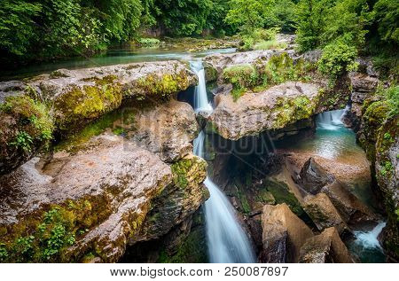 Amazing Forest Waterfall Flowing Into The Cold Mountain River With Large Stones. Martvili Canyon.