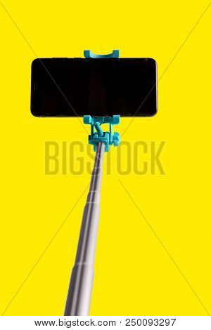 Monopod For Selfie With Smart Phone. Selfie Stick With Smartphone Isolated On Yellow Background.