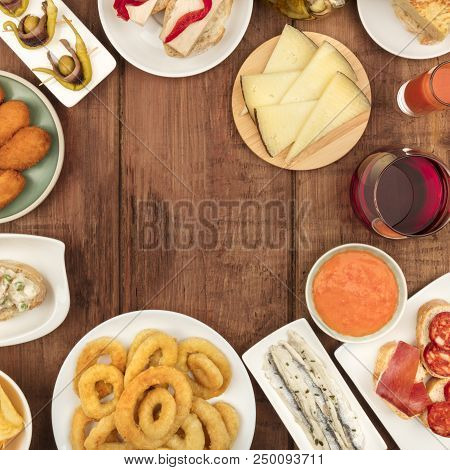 Spanish Food. Overhead Square Photo Of Various Spanish Tapas, Shot From Above On A Dark Rustic Textu