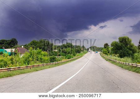 Asphalt Highway Road And Rainy Clody Dark Thunder Sky On Background. Bad Stormy Weather Forecast. Wa