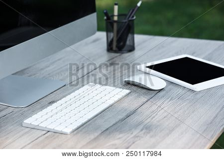 Selective Focus Of Digital Tablet And Computer With Blank Screens At Table Outdoors