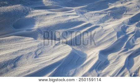 Beautiful Wavy Surface Of Freshly Fallen Snow In The Winter Season, The Surface Is Illuminated By Su
