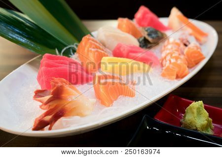 Mixed Sliced Fish Sashimi On Ice In White Bowl. Sashimi Salmon Tuna Hamachi Prawn And Surf Calm Set,