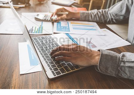 Business Accounting, Businessman Using Computer Laptop With Document And Caculator In Office, Saving