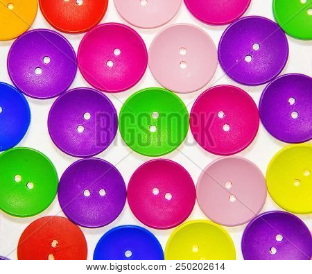 Colored Multicolored Wooden Buttons In The Background On White