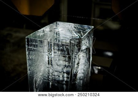 Unlighted Big Clear Ice Cube Standing On The Floor On The Ice Production Plant On The Blurred Backgr