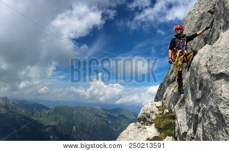 Young man climbing on a rock in Swiss Alps - via ferrata/klettersteig
