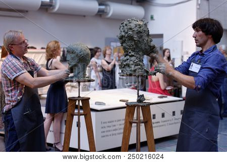 ST. PETERSBURG, RUSSIA - JULY 15, 2018: Sculptors Oleg Shorov (right) and Oleg Zhenilenko participate in artistic battle during the opening of festival Laboratory Of Sculpture in the museum workshop
