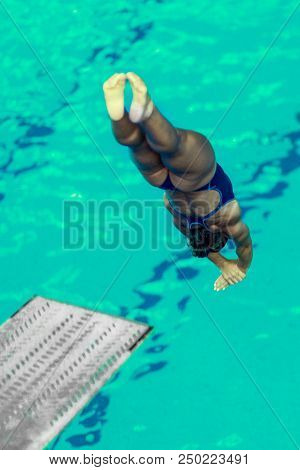 Female Diver Jumping Into The Pool