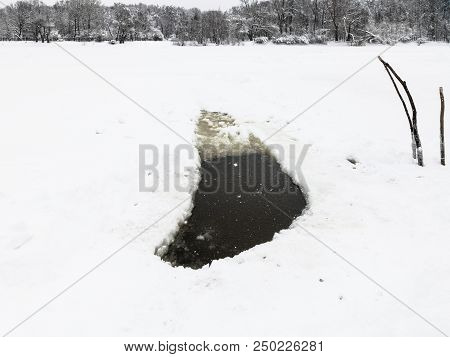 Ice Hole In Frozen Lake And View Of Urban Timiryazevskiy Park In Moscow City In Winter Snowfall