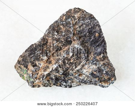 Macro Shooting Of Natural Mineral - Rough Chromite Stone On White Marble From Ural Mountains