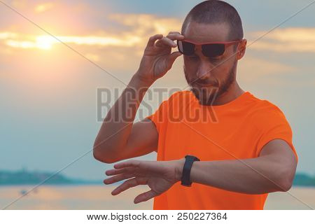 Checking The Time After Exercising / Jogging Outdoors. Optical Focus Is On The Hand And Watch.