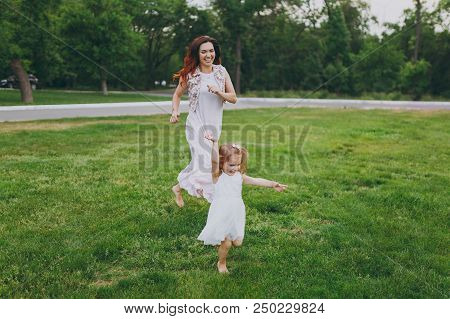 Joyful Woman In Light Dress Running Catching Up Have Fun With Little Cute Child Baby Girl On Green G