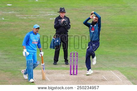 LEEDS, ENGLAND - JULY 17: Moeen Ali bowling as umpire Paul Reiffel and MS Dhoni look on during the 3rd Royal London One day International match between England and India at Headingley Cricket Ground