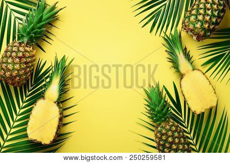 Pineapples And Tropical Palm Leaves On Punchy Pastel Yellow Background. Summer Concept. Creative Fla