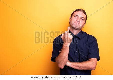 Rude Male Portrait Showing Middle Finger On Orange Background