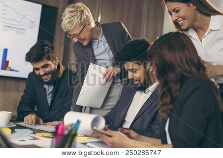 Group Of Business People Working In An Office, Executive Signing A Contract. Focus On The Man Signin