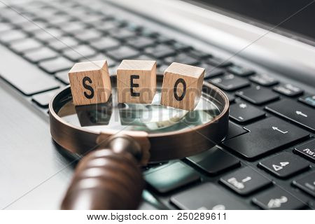 A Vintage Magnifying Glass With Seo Blocks On A Black Tablet Keyboard - Search Engine Optimization C