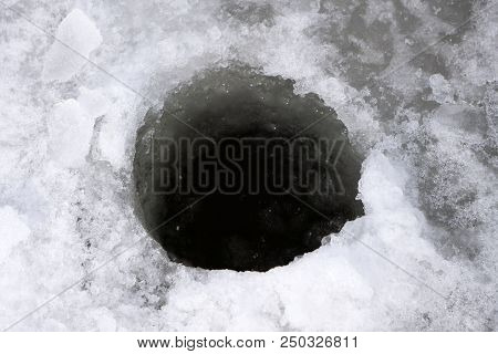 Ice-hole In Ice On A Pond, Left Fishermen