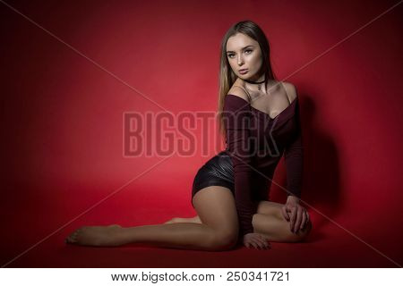 Portrait Of Sexy Woman In Studio Of Red Backgraund