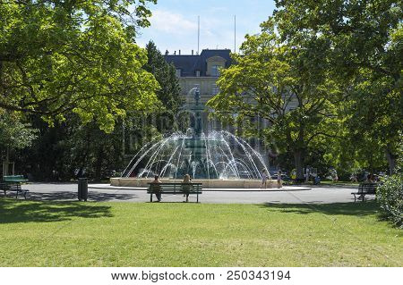 Geneva, Switzerland - July 2018: A Fountain Plays In The Jardin Anglais In The Centre Of Geneva