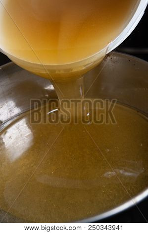 Strain The Poured Honey Through A Sieve. How To Harvest Honey. Filtering Raw Honey.